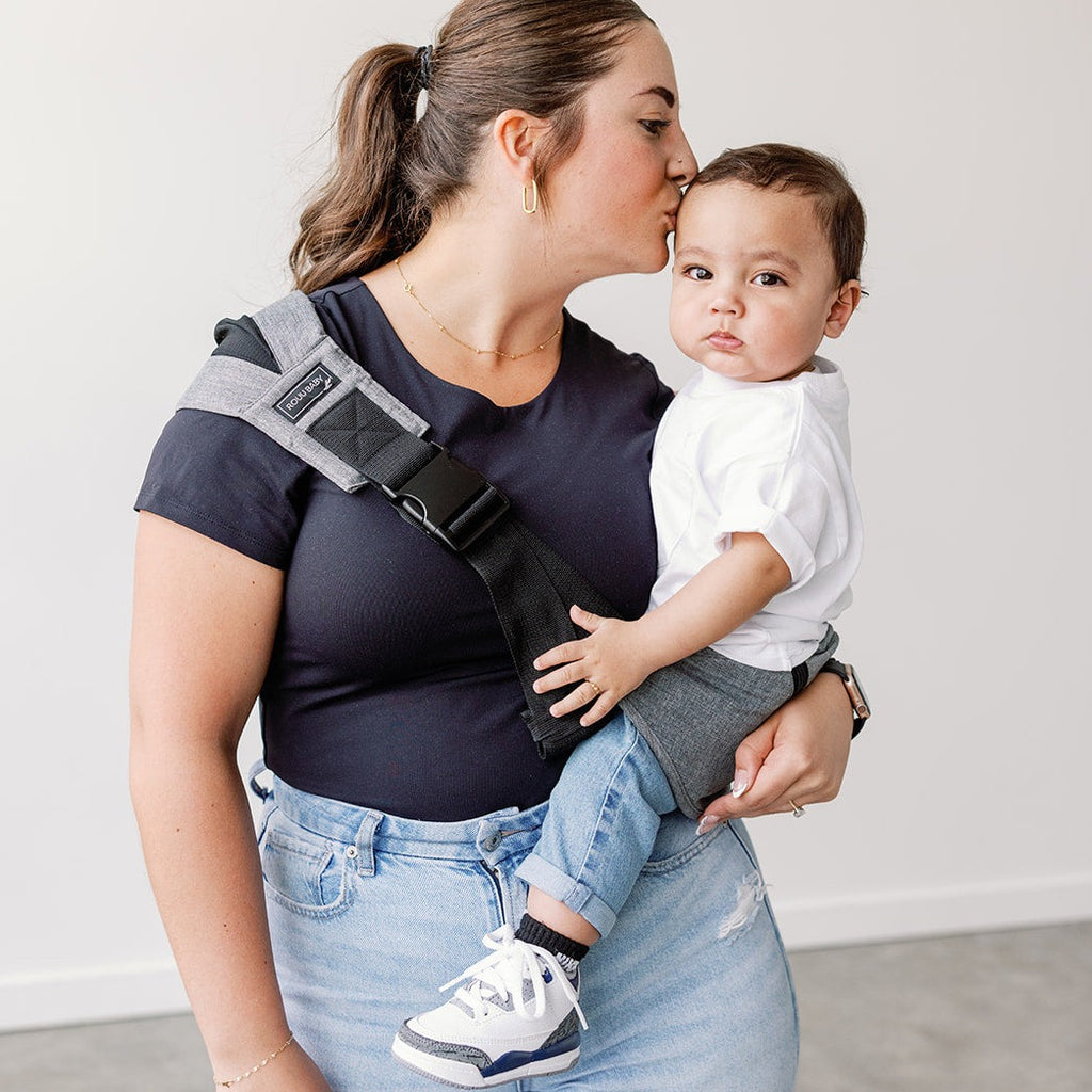 Baby seated in the Rouu Baby II Lux Graphite ergonomic hip carrier